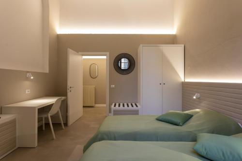 a bedroom with two beds and a desk and a sink at Palazzo dei Ciompi Suites in Florence