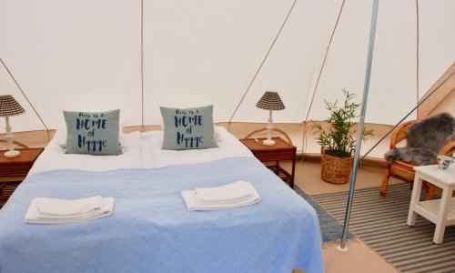 a bed in a tent with two towels on it at Pension Lærkelill in Skovlund