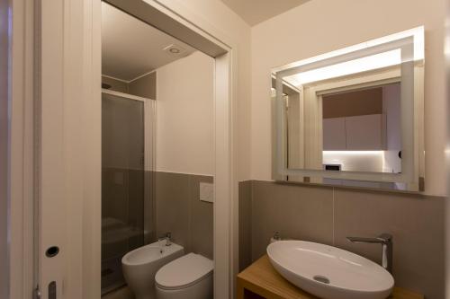 a bathroom with a sink and a toilet and a mirror at Palazzo dei Ciompi Suites in Florence