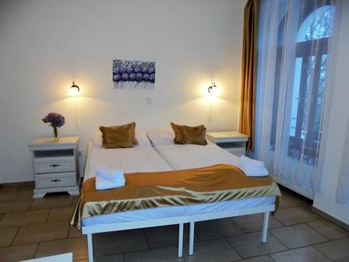 ein Schlafzimmer mit einem Bett mit zwei Nachttischen und einem Fenster in der Unterkunft Pension Na Hradbach in Tábor