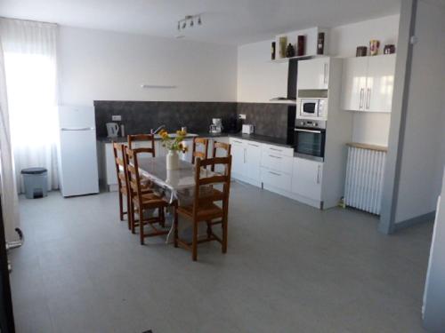une cuisine avec une table et des chaises dans une pièce dans l'établissement Maison Chez Nous, à Royan