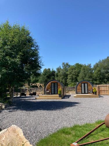 a couple of cottages on a gravel driveway at Loch Ness Pods in Fort Augustus