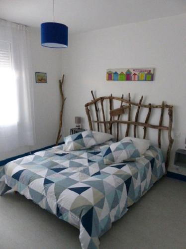 - une chambre avec un lit en bois bleu clair dans l'établissement Maison Chez Nous, à Royan