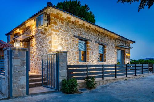 a stone house with a fence in front of it at ADRIAN'S LUXURY APARTMENTS 2 in Dhrepanon