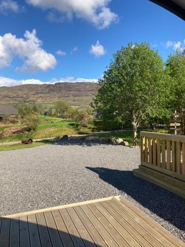 a wooden bench sitting on top of a gravel yard at Loch Ness Pods in Fort Augustus