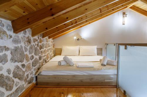 a bed in a room with a stone wall at ADRIAN'S LUXURY APARTMENTS 2 in Dhrepanon