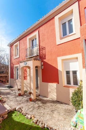 a red and white house with a balcony at Casa Rural La Rosaleda de Pajares in Pajares