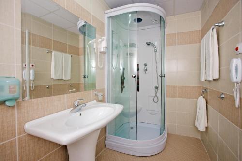 a bathroom with a sink and a glass shower at Hotel Kotva - All Inclusive in Sunny Beach