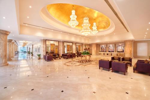 a lobby of a hotel with tables and chairs at Accord Puducherry in Puducherry
