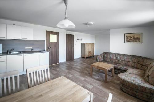 a living room with a couch and a table and a kitchen at Ubytování Filipova Hora in Tlumačov