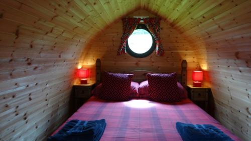 um quarto com uma cama num chalé de madeira em Woodbatch Camping & Glamping em Bishops Castle