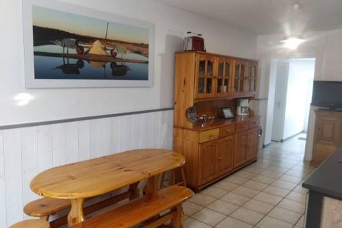 - une cuisine avec un banc en bois dans l'établissement LA MAISON BLEUE, à Bouin