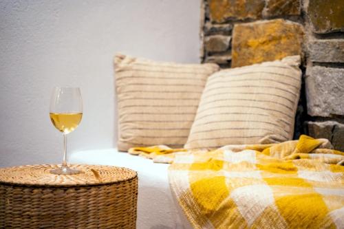 a glass of wine sitting on a table next to a bed at Cato Agro 1, Seafront Villa with Private Pool in Karpathos Town
