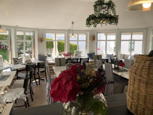 restauracja ze stołami i krzesłami oraz wazonem kwiatów w obiekcie Nautic Hotell w mieście Marstrand