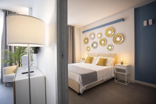 a bedroom with a bed and mirrors on the wall at Acquarò Suite Apartments in San Vito lo Capo