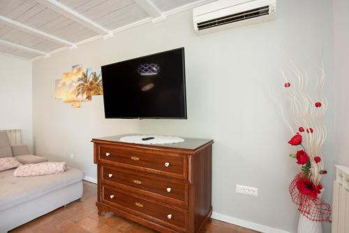 a bedroom with a dresser and a tv on a wall at Villa Ruza in Selina