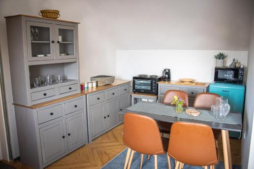 a kitchen with a table and orange chairs in it at Apartmány u Petry in Luhačovice