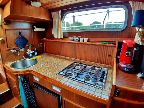 Motor Yacht Amstelle في أمستردام: مطبخ صغير مع موقد ومغسلة