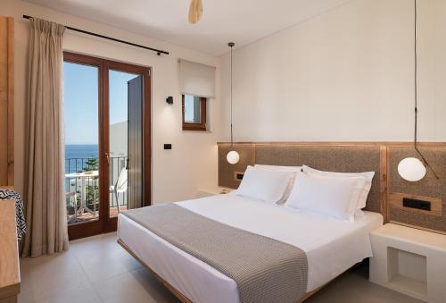 a bedroom with a bed with a view of the ocean at The Authentic Village Boutique Hotel in Khóra Sfakíon