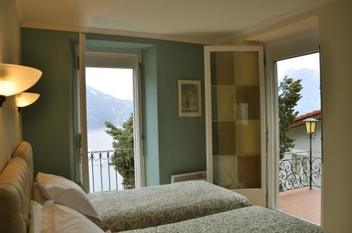 ルガノにあるVilla Sassaltoのベッドルーム(ベッド1台付)、バルコニーが備わります。