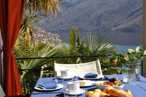 a table with food on it with a view of a lake at Villa Sassalto in Lugano
