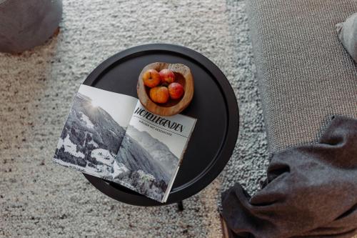 a table with a bowl of fruit and a magazine at Ferienwohnungen Johanneshof in Maria Alm am Steinernen Meer