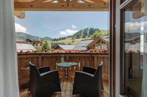 a balcony with a table and chairs and a view at Ferienwohnungen Johanneshof in Maria Alm am Steinernen Meer