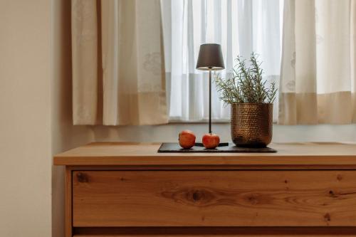 a table with a lamp and a potted plant on it at Ferienwohnungen Johanneshof in Maria Alm am Steinernen Meer