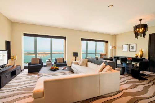 a living room with a couch and a piano at Sofitel Abu Dhabi Corniche in Abu Dhabi