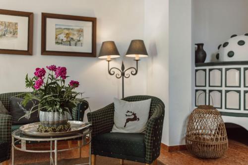 a living room with two chairs and a table with flowers at Ferienwohnungen Johanneshof in Maria Alm am Steinernen Meer