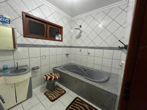 a bathroom with a tub and a sink at Casa de Campo com piscina e churrasqueira a 10min do Centro Domingos Martins in Domingos Martins