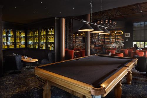a pool table in a bar with alcohol bottles at Le Grand Hôtel Le Touquet-Paris-Plage in Le Touquet-Paris-Plage