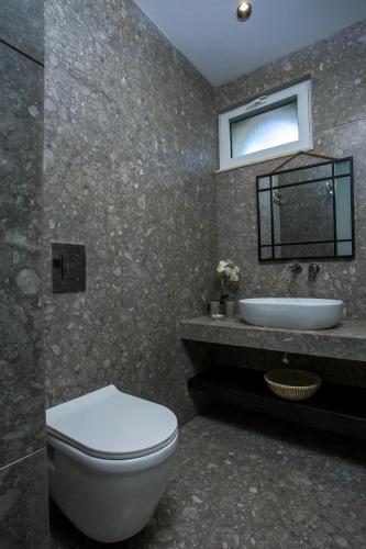 a bathroom with a toilet and a sink at Dias Studios & Suites in Faliraki