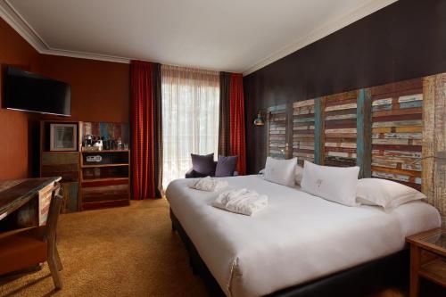 a bedroom with a large white bed in a room at Le Grand Hôtel Le Touquet-Paris-Plage in Le Touquet-Paris-Plage