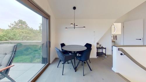 a kitchen and dining room with a table and chairs at Haus Kleemann K4 in Norderney