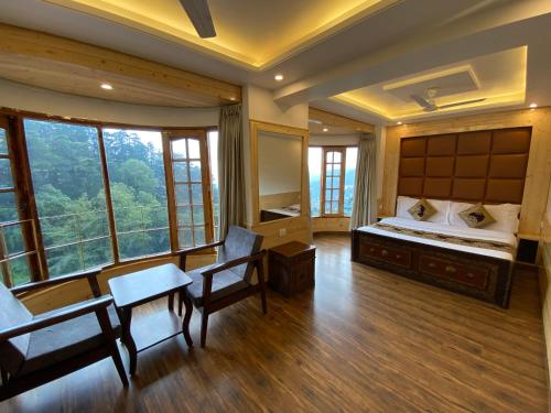 een slaapkamer met een bed en een tafel en stoelen bij Hotel Silverine in Shimla