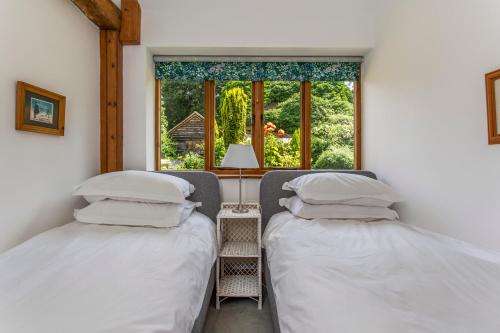 two twin beds in a room with a window at Carters Barn in Chipping Campden