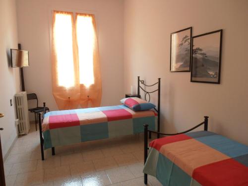 sypialnia z dwoma łóżkami i oknem w obiekcie B&B Timo e Rosmarino w mieście Sermide