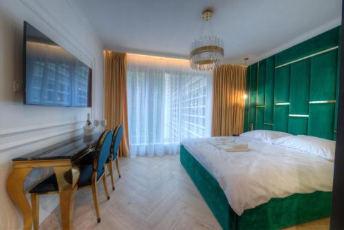 1 dormitorio con cama, escritorio y mesa en Luxury Del Sol Apartments Świnoujście en Świnoujście