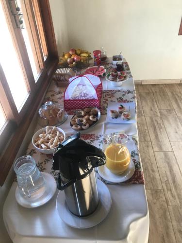 a table topped with plates of food and desserts at Chalés do Recanto in São João del Rei