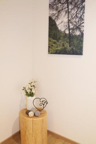 a table with a plant and a picture on the wall at Lindbichlhof Urlaub am Bio Bauernhof in Sankt Johann im Pongau