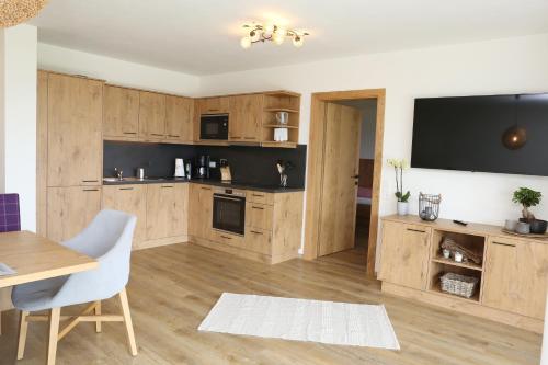 a kitchen with wooden cabinets and a tv on the wall at Lindbichlhof Urlaub am Bio Bauernhof in Sankt Johann im Pongau