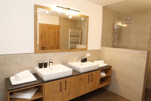 a bathroom with two sinks and a mirror at Lindbichlhof Urlaub am Bio Bauernhof in Sankt Johann im Pongau