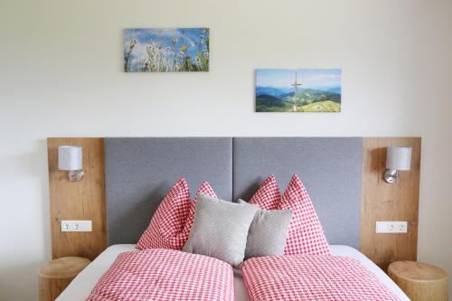 a bedroom with a bed with red and white pillows at Lindbichlhof Urlaub am Bio Bauernhof in Sankt Johann im Pongau