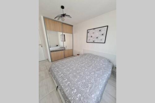 a bedroom with a bed and a mirror in it at Saint Raphaël, bel appartement en centre ville ! in Saint-Raphaël