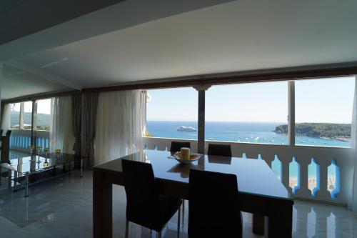 a dining room with a table and a view of the ocean at Valtos View in Parga