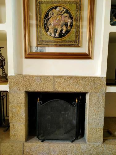 a fireplace with a painting on the wall at Ca la Magda in Camarasa