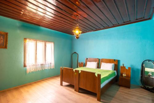 1 dormitorio con 1 cama en una habitación azul en Theatre Old Town House, en Bitola