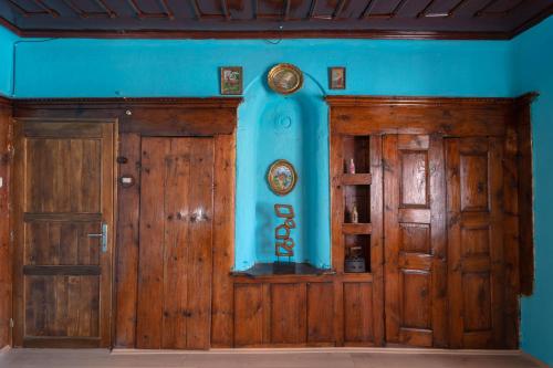 Theatre Old Town House في بيتولا: غرفة ذات بابين خشبي وجدار أزرق