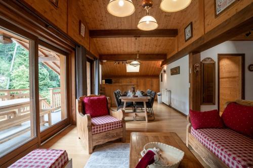 a living room with a table and some chairs at Chalet familial Fleurs des Bois - Rochebrune in Megève